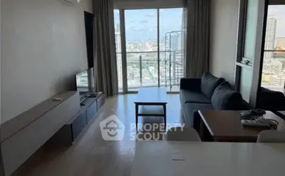 Modern living room with city view, sleek furniture, and natural light.