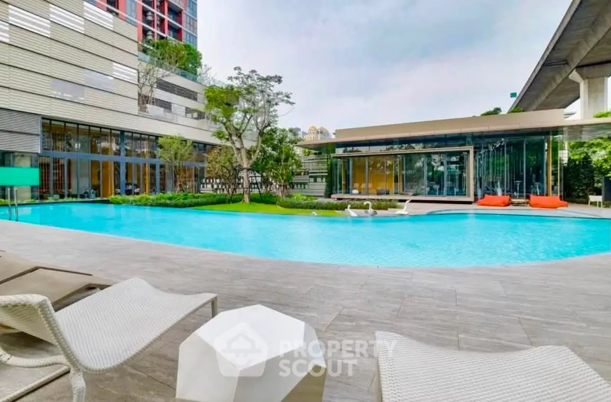 Luxurious modern apartment complex with a stunning outdoor pool and stylish lounge area.