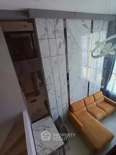 Luxurious modern living room with marble accents and stylish orange sofa