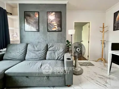 Modern living room with stylish decor, featuring a gray sofa, elegant wall art, and sleek marble flooring.