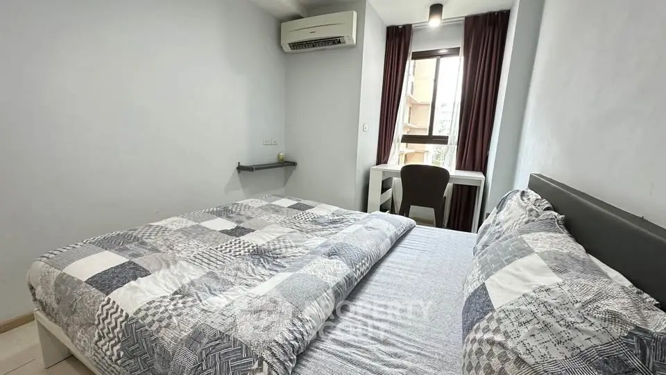 Cozy bedroom with modern decor, featuring a large bed, air conditioning, and a study desk by the window.