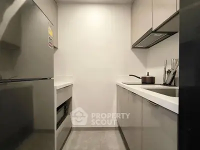 Modern compact kitchen with sleek cabinetry and built-in appliances