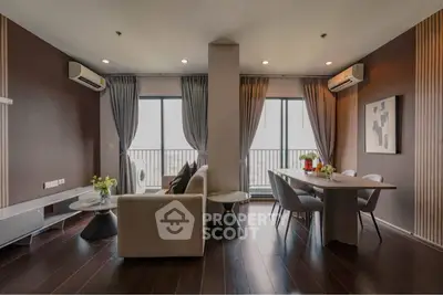 Modern living room with elegant decor and large windows leading to a balcony.