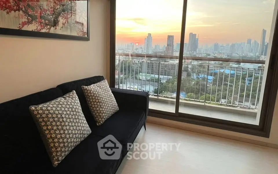 Chic living room with stunning city view from high-rise balcony at sunset.