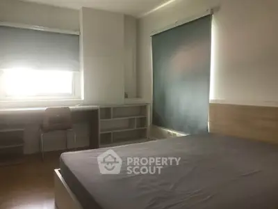 Spacious bedroom with natural light and modern furnishings