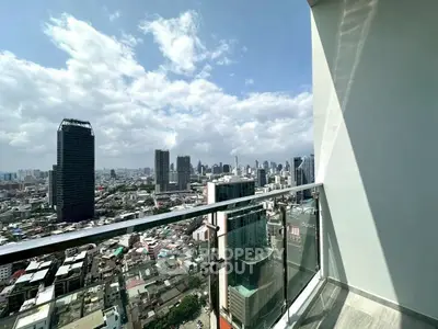 Stunning cityscape view from modern high-rise balcony with glass railing.