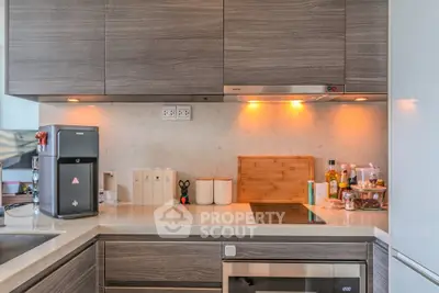 Modern kitchen with sleek cabinetry and built-in appliances, featuring a stylish countertop and ambient lighting.