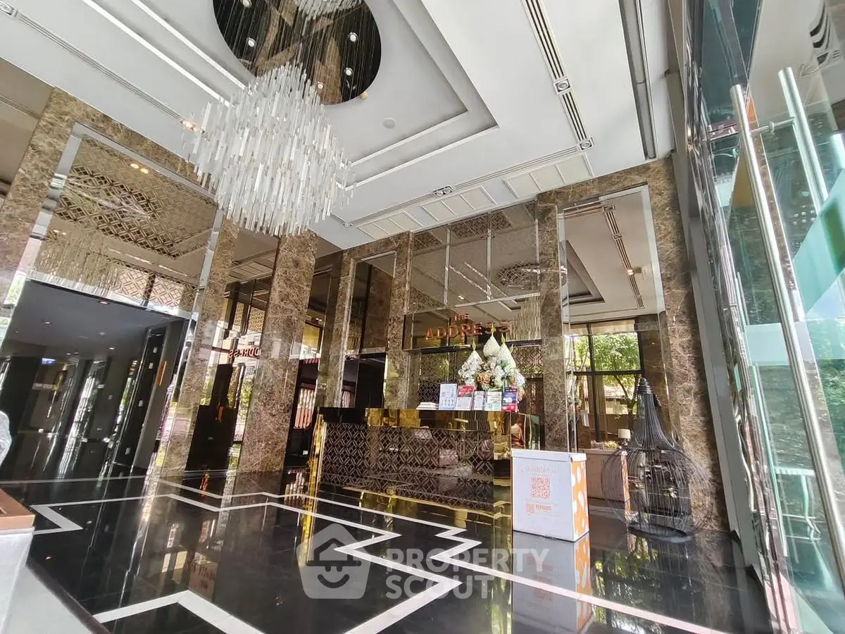 Luxurious building entrance with elegant chandelier and marble decor