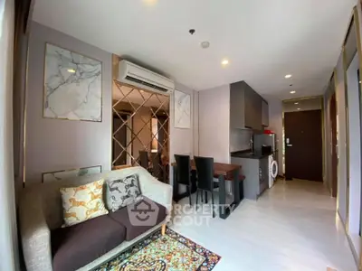 Modern living room with stylish decor and compact kitchen in open layout apartment.