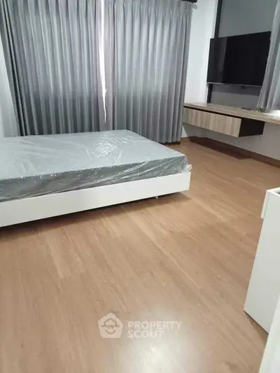 Spacious bedroom with modern design and large window for natural light.