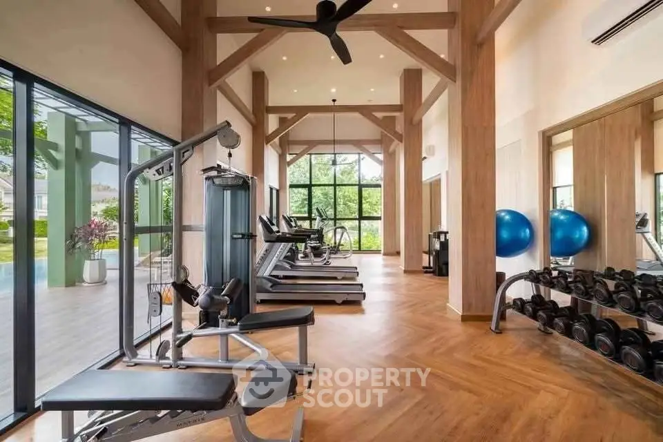 Spacious modern gym with state-of-the-art equipment and large windows for natural light.