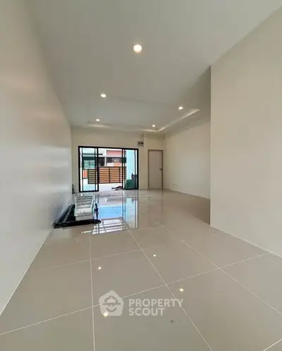 Spacious modern living room with glossy tiled floors and large windows for natural light.
