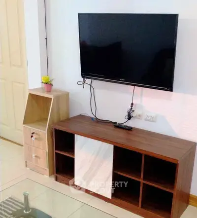 Modern living room with wall-mounted TV and stylish wooden cabinet