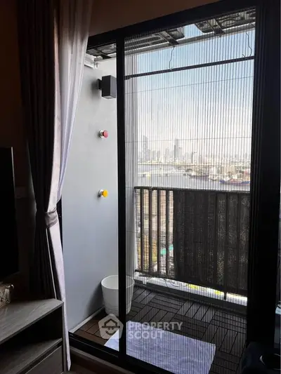 Modern balcony with city view, featuring sliding glass doors and stylish flooring.