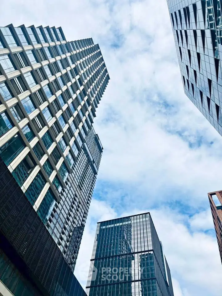 Stunning modern skyscrapers with glass facades against a bright blue sky, showcasing urban architectural elegance.