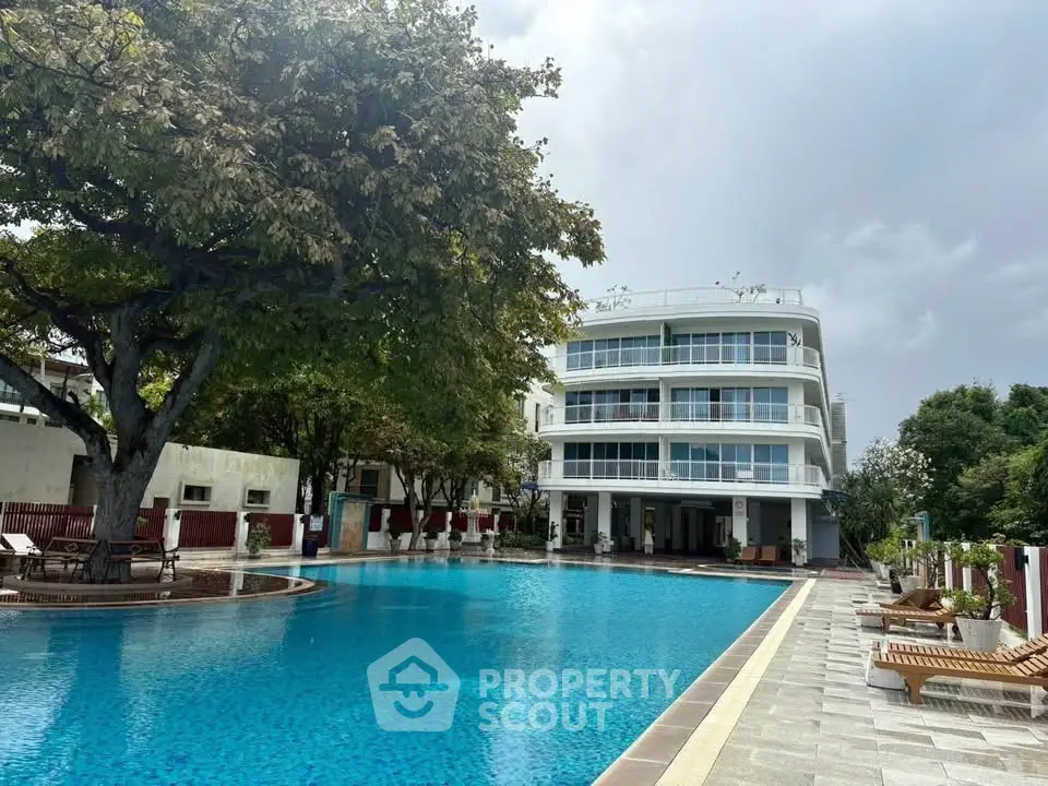 Luxurious apartment complex with stunning pool and lush greenery