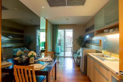 Modern open-plan living and dining area with stylish kitchen and cozy seating, featuring elegant decor and natural light.