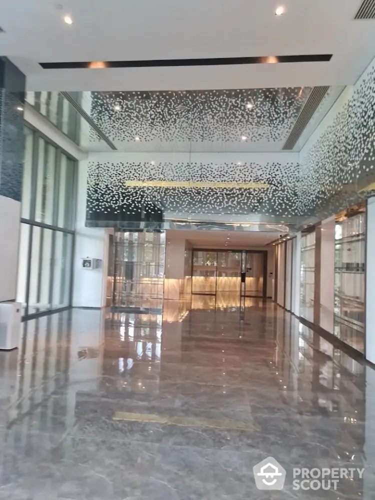 Luxurious modern building entrance with elegant marble flooring and artistic ceiling design