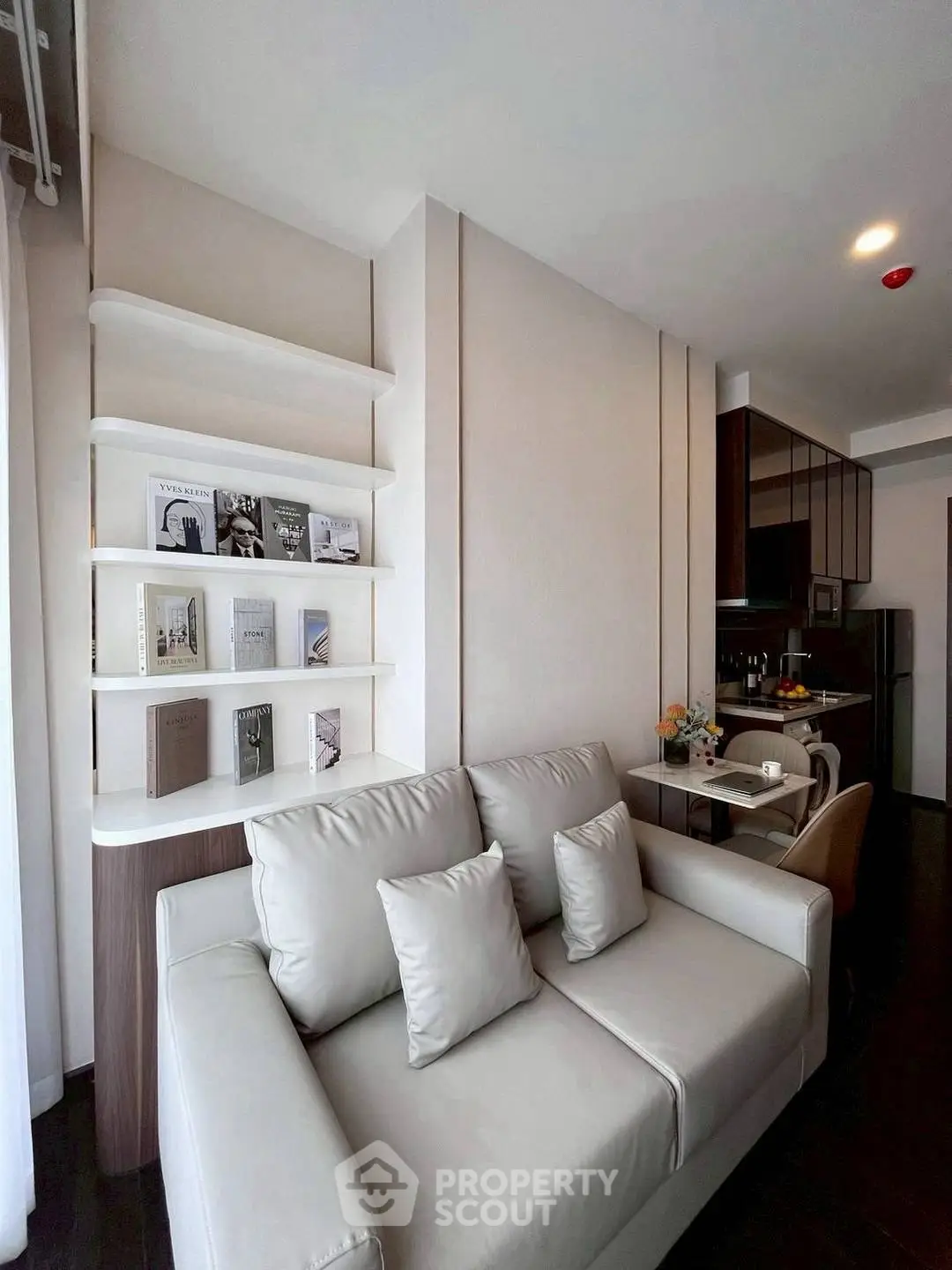 Modern living room with sleek sofa and stylish bookshelf in open layout apartment.