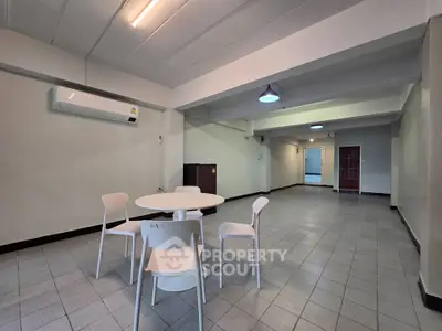 Spacious open-plan living area with minimalist furniture and tiled flooring