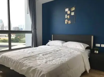 Modern bedroom with city view and stylish blue accent wall