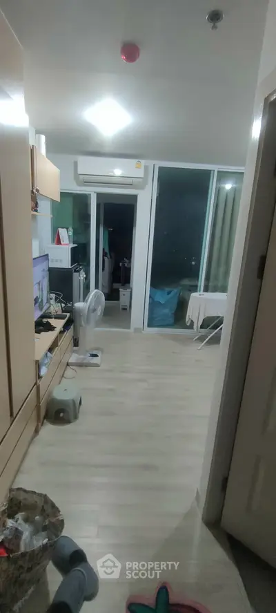 Cozy apartment interior with modern furnishings and balcony access, ideal for urban living.