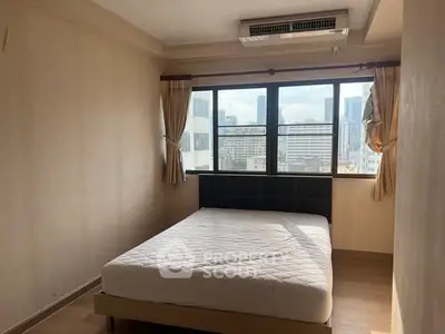 Spacious bedroom with city view, featuring large window and comfortable bed.