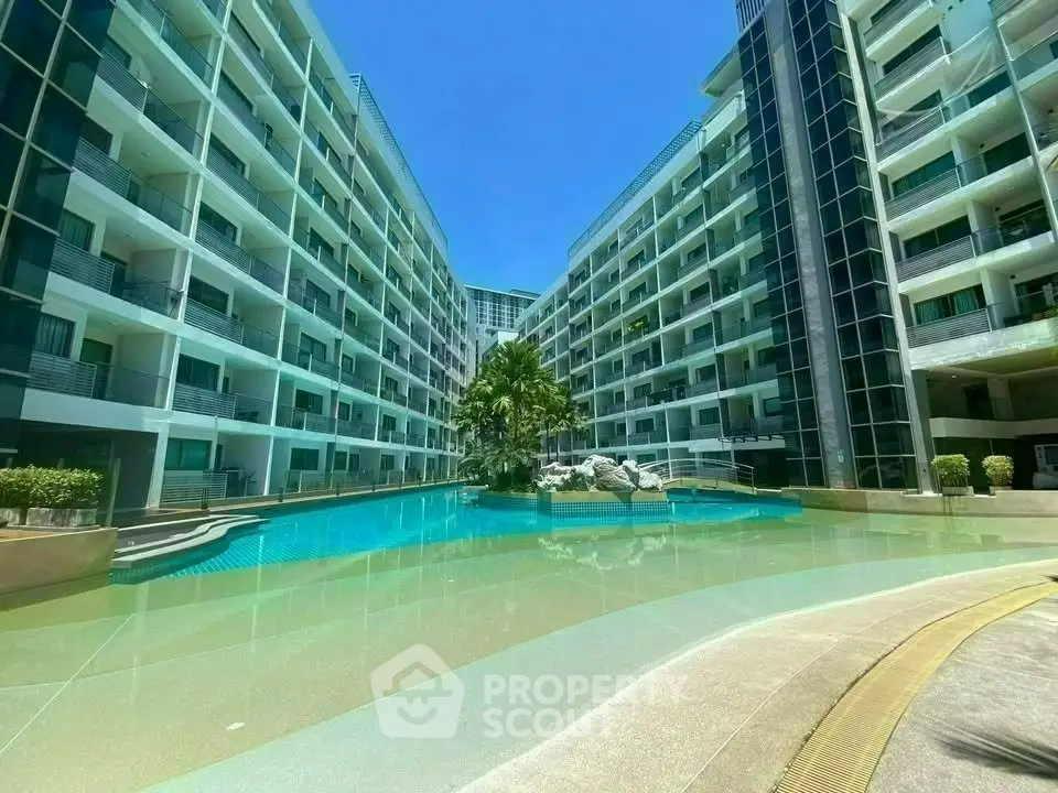 Luxurious modern apartment complex with stunning pool and lush greenery.