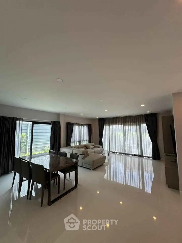 Spacious modern living room with large windows and elegant furniture