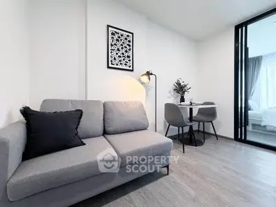 Modern living room with gray sofa and dining area in stylish apartment