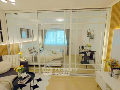 Modern studio apartment with stylish decor and glass partition separating bedroom and living area.