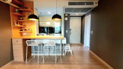 Modern apartment interior with stylish kitchen and dining area, featuring sleek design and contemporary lighting.