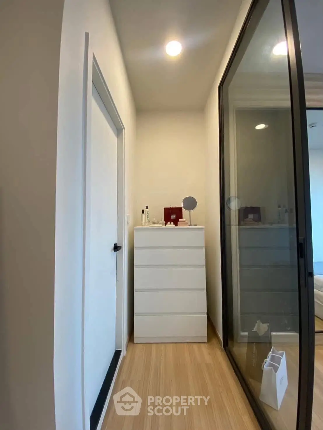 Modern interior with sleek storage and glass sliding door, perfect for compact living spaces.