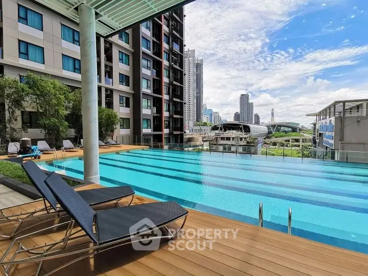 Luxurious apartment complex with stunning pool and city skyline view, perfect for urban living.