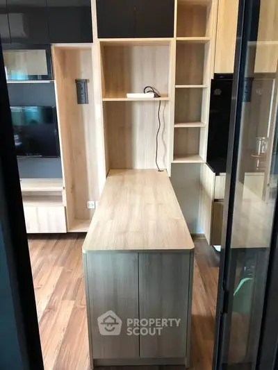 Modern kitchen with sleek wooden cabinetry and integrated appliances in a stylish apartment.