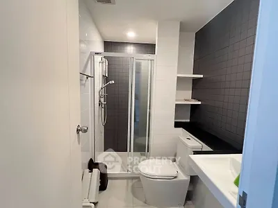 Modern bathroom with sleek shower and contemporary fixtures in a stylish apartment.