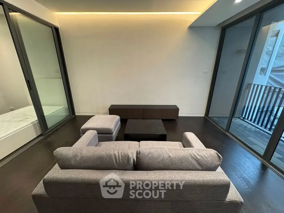 Modern living room with sleek furniture and large windows for natural light.