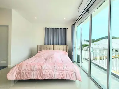 Spacious bedroom with large windows and balcony access, offering stunning views and natural light.