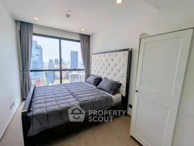 Luxurious bedroom with stunning city view and elegant decor in high-rise apartment.