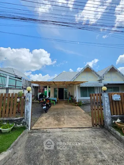Charming single-story home with driveway and front garden under a bright blue sky.