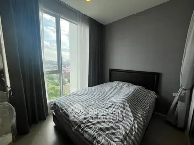 Modern bedroom with large window offering stunning city view, featuring cozy bed and elegant decor.