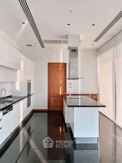 Luxurious modern kitchen with sleek black countertops and high-end appliances in a bright, spacious setting.