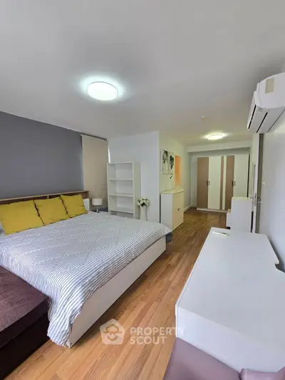 Spacious bedroom with modern decor and ample storage in a stylish apartment.