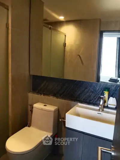 Modern bathroom with sleek fixtures and elegant design, featuring a glass shower and stylish sink.