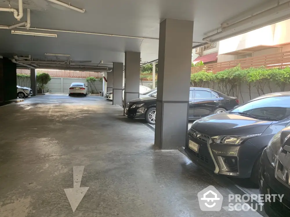 Spacious covered parking area with multiple cars in a residential building