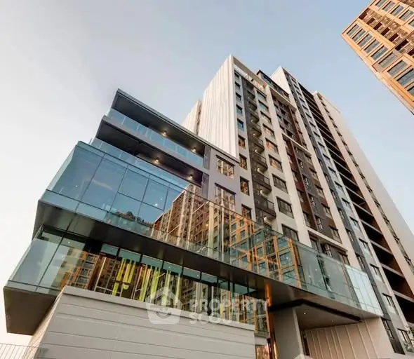 Modern high-rise building with glass facade and sleek architectural design.