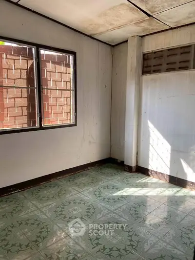 Spacious room with tiled floor and large window, perfect for customization.
