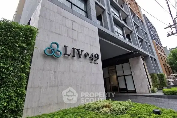 Modern building entrance with sleek design and lush greenery at LIV@49.
