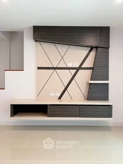 Modern interior wall unit with geometric design and built-in shelves in a stylish living room.