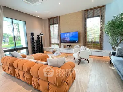 Luxurious living room with modern decor and large windows offering garden views.